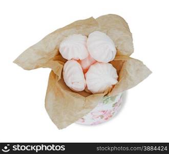 Several meringues in the round pasteboard box in the packaging paper isolated on white background