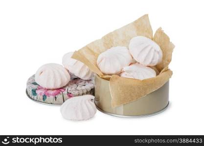 Several meringues in the round tin box in the packaging paper isolated on white background