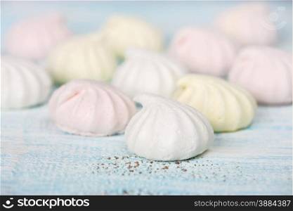 Several multi-colored meringues closeup on wooden background