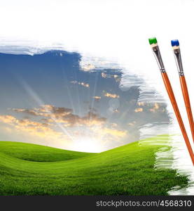 several paintbrushes and nature landscape on the background