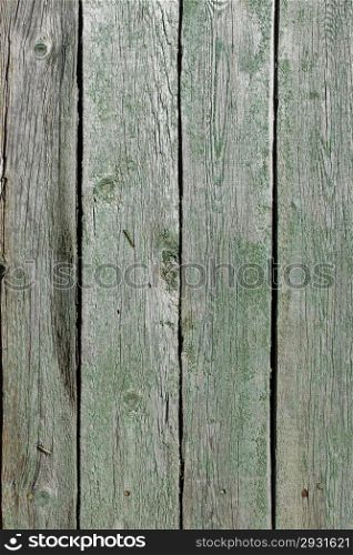 Several parallel old wooden boards with very ragged green paint