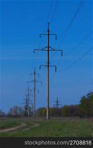 several pillars power lines against the blue sky
