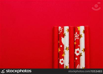 several red and white straws on a red background with copy space.. several red and white straws on a red background with copy space
