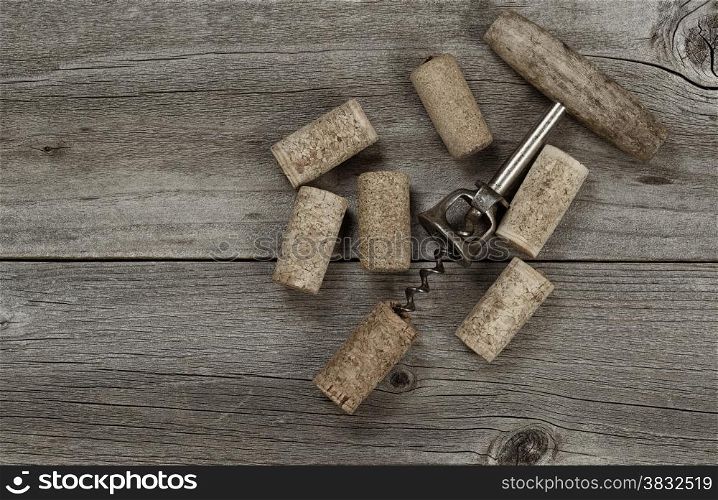 Several used corks and opener on aged cedar wooden boards in vintage style. Top view angled shot in horizontal format with copy space.