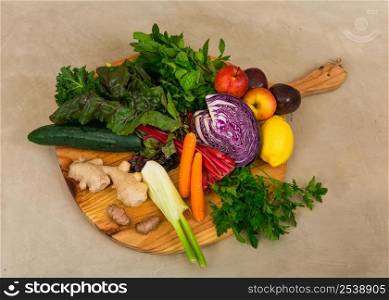 Several vegetables on top of a wooden board. Ingredients for detox diet.