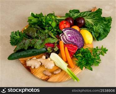 Several vegetables on top of a wooden board. Ingredients for detox diet.