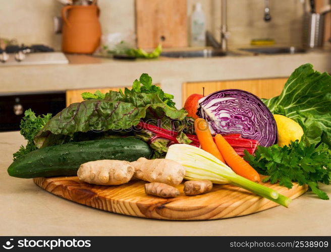 Several vegetables on top of a wooden board. Ingredients for detox diet.