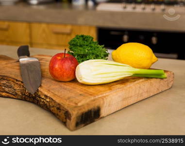 Several vegetables on top of a wooden board. Ingredients for detox juice.