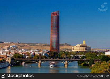 Sevilla. City embankment along the Guadalquivir.. View of urban embankment in Seville along the Guadalquivir river by day. Spain. Andalusia.