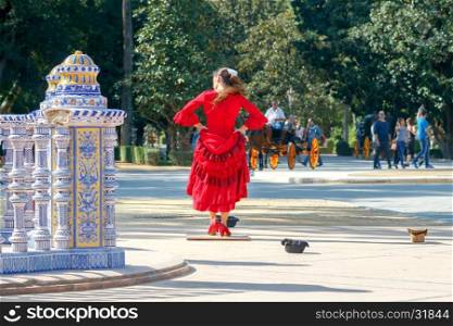 Seville. Spanish Square or Plaza de Espana.. Flamenco dancer in red dress dancing on the Spanish Square . Seville. Andalusia.