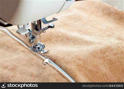 sewing a white zipper on a sewing machine. sewing process. sewing machine and zipper