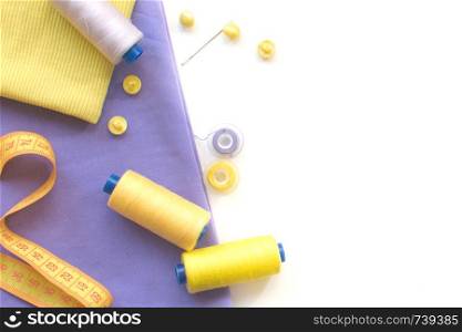 Sewing accessories and fabric on a white background. Threads, needle, fabric, buttons and sewing centimeter. top view. Sewing accessories and fabric on a white background. Fabric, sewing threads, needle, buttons and sewing centimeter. top view, flatlay