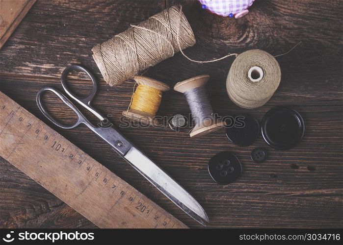 Sewing instruments, threads, needles in vintaae style. Sewing instruments, threads, needles, bobbins and materials. Studio photo