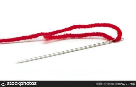Sewing needle and red thread close up. White isolated .