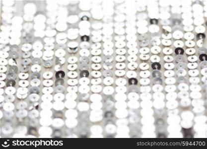 sewing, texture, background, design and embroidery concept - close up of silver sequined textile texture