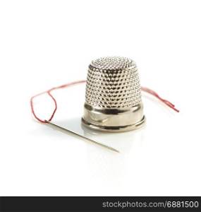 sewing thimble and thread with needle isolated on white background