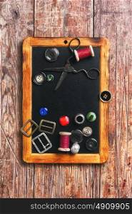 Sewing thread and buttons. Set of buttons and sewing thread on the chalk board for drawing