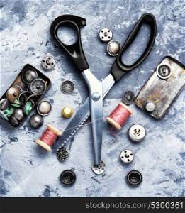 Sewing thread, buttons and scissors. Metal buttons for clothes, scissors and sewing threads