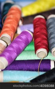 Sewing threads in diverse colors. Clothing and fashion concept