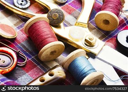 Sewing tools, scissors, buttons and threads on fabric.Sew. Sewing accessories and fabric