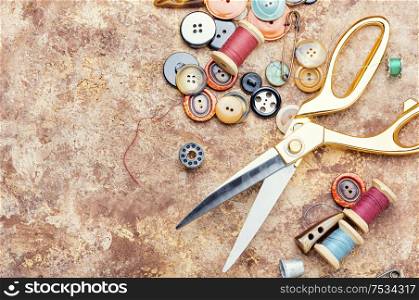 Sewing tools, scissors, many buttons and threads.Space for text. Tools for sewing