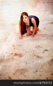 Sexual brunette woman in dress on the beach sand