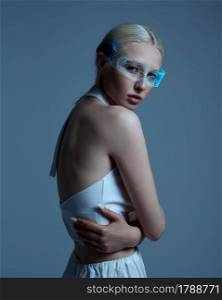 Sexual futuristic woman in white clothes and modern glasses, grey background. Sexy female person in virtual reality style, future technology, futurism concept. Sexual futuristic woman in modern glasses