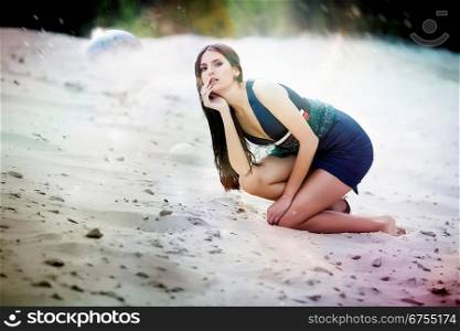 Sexual woman in blue dress on the cosmic beach sand