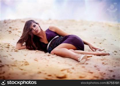 Sexual woman in dress laying on the cosmic beach