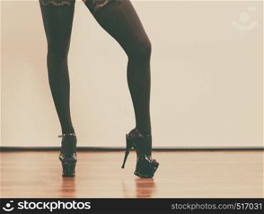 Sexuality of women. Part body woman wearing black sexy stockings. Long female legs in high heels.. Sexy long female legs in black.