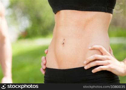 Sexy and fit belly on young woman against blur background