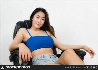 Sexy asian women wearing a blue single-breasted dress sitting in a chair in the office.