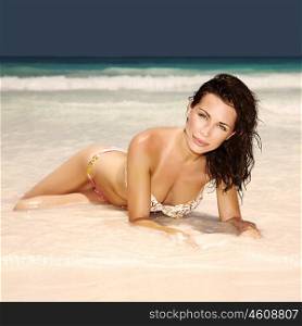 Sexy attractive woman lying down on the beach, perfect body, healthy lifestyle, relaxation outdoors, enjoying dayspa, summer vacation, sensuality concept