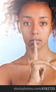 sexy beautiful mulatto woman is touching her lips with finger on sky background