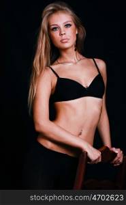 Sexy blond in black lingerie over dark background