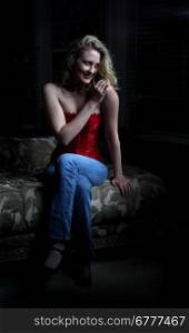 Sexy blond woman sitting in the dark.