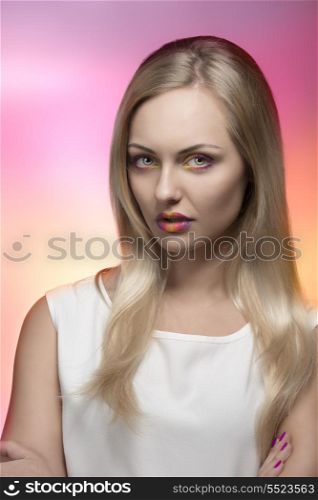 sexy blonde girl posing with creative colorful make-up, long silky smooth hair and white dress