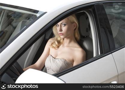 sexy blonde woman with elegant style sitting in a white car