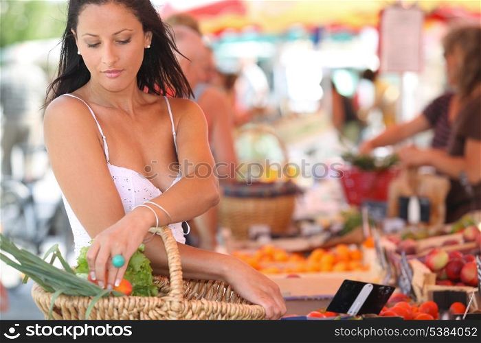 sexy brunette buying vegetables at open air market