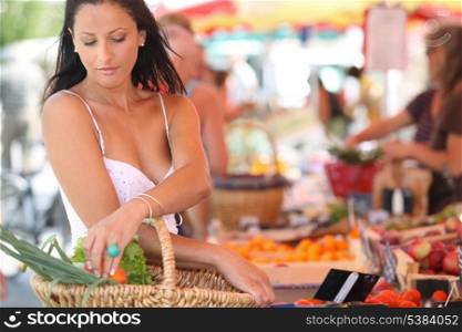 sexy brunette buying vegetables at open air market