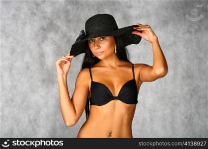 sexy brunette in black bikini and bonnet isolated on white background