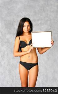 sexy brunette in black bikini with blank frame isolated on white background
