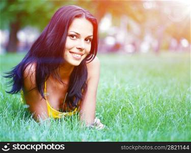 sexy brunette in dress on the background of green grass