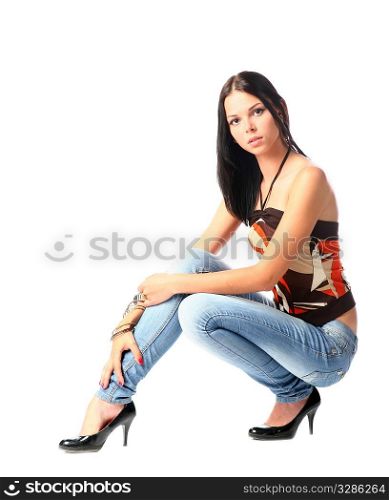 sexy brunette in jeans in sitting position isolated on white background