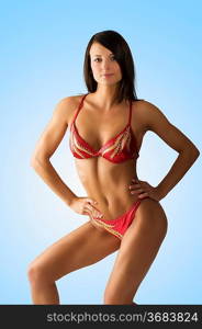 sexy brunette in red bikini taking body builder pose