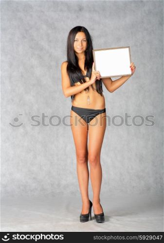 Sexy brunette with blank frame in her hands.