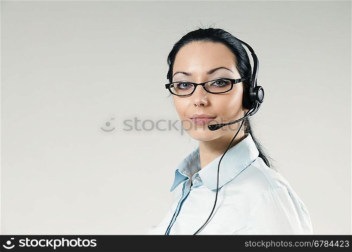 Sexy call center operator full face portrait. Sexy girl wearing headset and glasses standing on uniform background. One of a series.