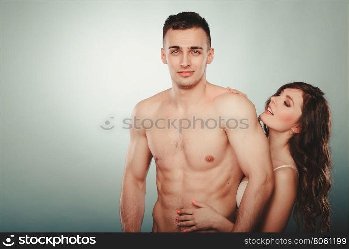Sexy couple. Half naked man and woman in lingerie.. Sexy passionate young couple lovers embracing in studio. Handsome muscled half naked semi nude man and pretty gorgeous woman in lingerie. Love and passion.