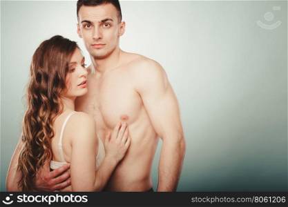 Sexy couple. Half naked man and woman in lingerie.. Sexy passionate young couple lovers embracing in studio. Handsome muscled half naked semi nude man and pretty gorgeous woman in lingerie. Love and passion.