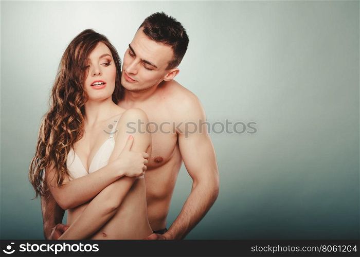Sexy couple. Half naked man and woman in lingerie.. Sexy passionate couple in studio. Handsome half naked semi nude man and pretty woman in lingerie. Love and passion.